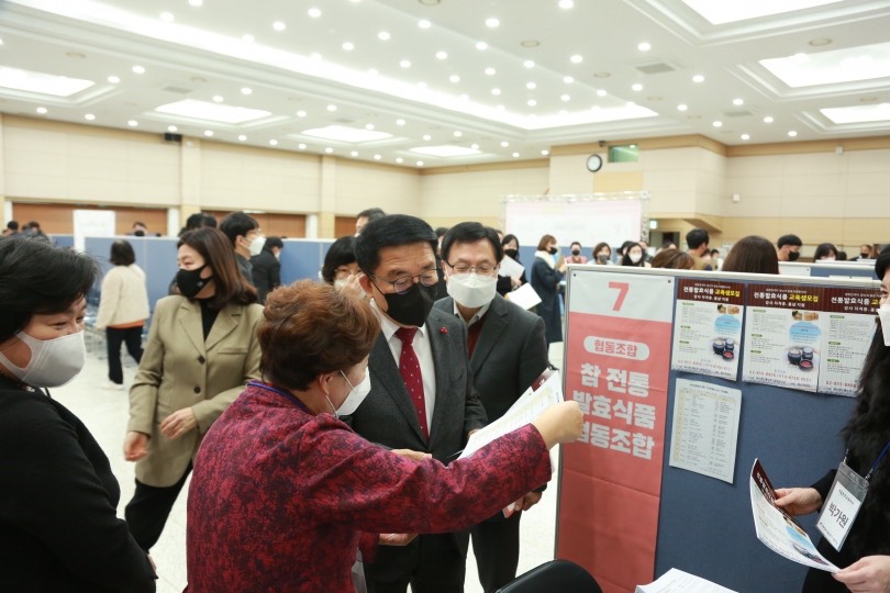 공공박람회 조합 부스에서 방문객에게 제품을 안내하는 모습
